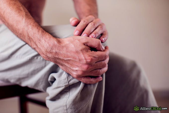 CBC vs CBD: man holding his knee in pain