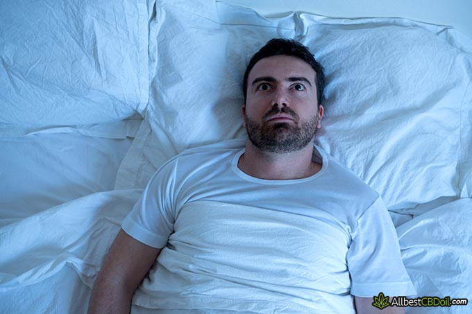 Best CBD for sleep: a man with his eyes open, unable to fall asleep.