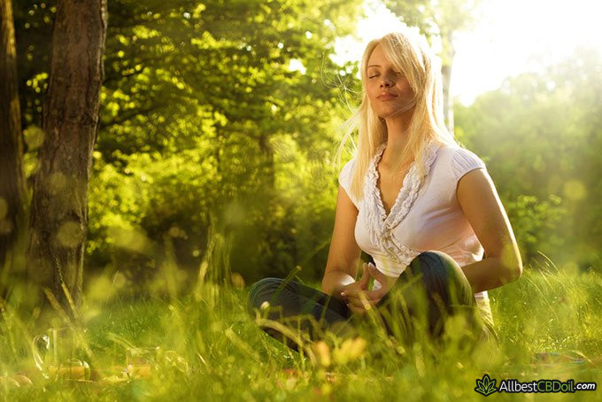 Endocannabinoid System and CBD:  calm and content woman sitting in the nature