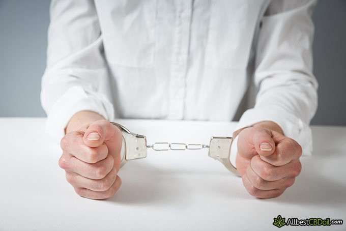 Full-spectrum CBD oil: hands with handcuffs