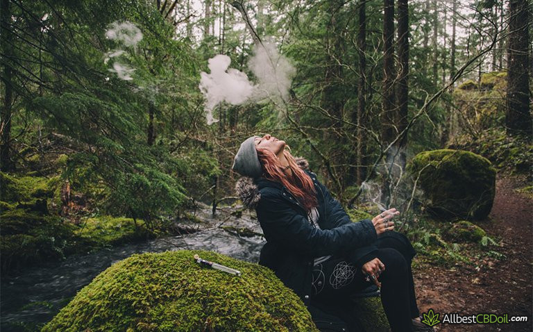 CBD overdose: woman smoking weed in the forest CBD overdose: woman smoking weed in the forest